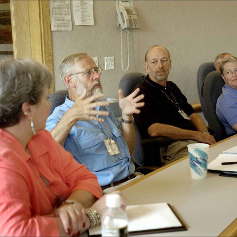 People seated around a conference table in a business meeting