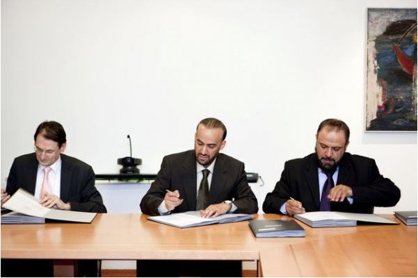 A hand signing a contract document with a pen